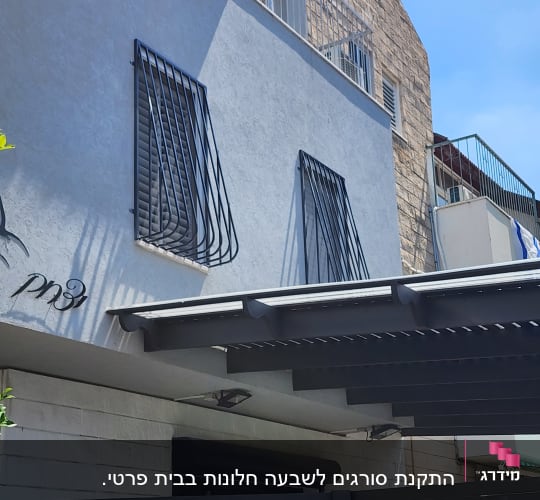 סורגים שחורים על חלונות קיר חיצוני